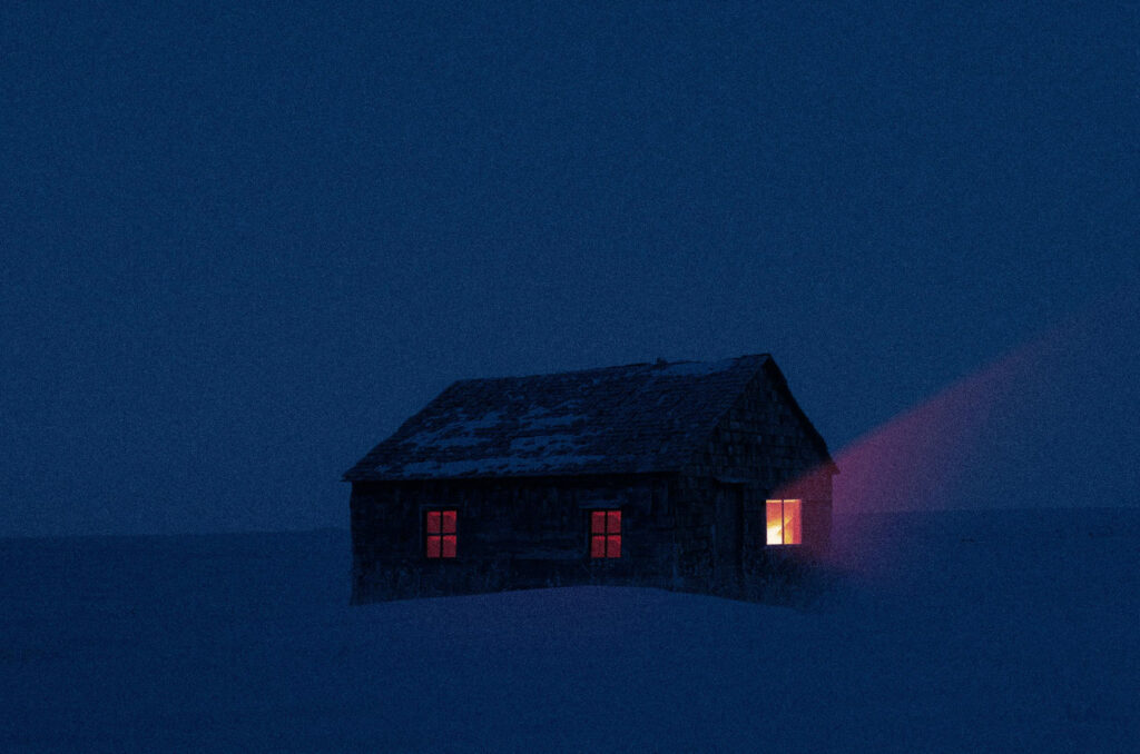 Cabin at night in the snow with a warm glow emanating because there's plenty of power from the portable power station